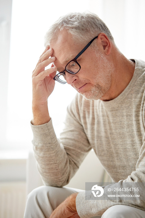 senior man suffering from headache at home