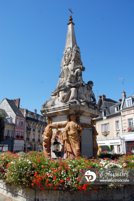 Ville de Noyon, Fontaine du Dauphin (XVIIIe siècle) entourée de fleurs rouges et blanches, département de l’Oise, France