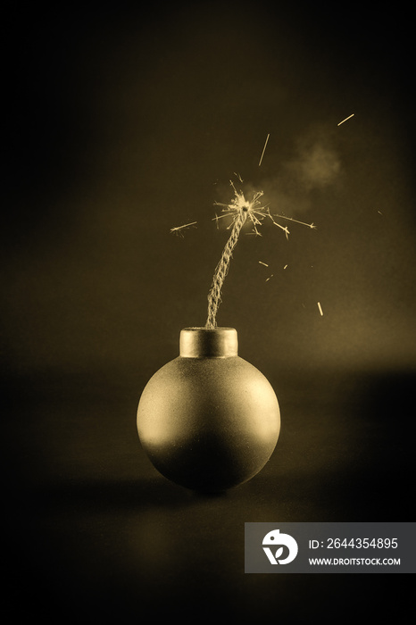 A bomb with a lit fuse on a dark background. Explosion hazard.