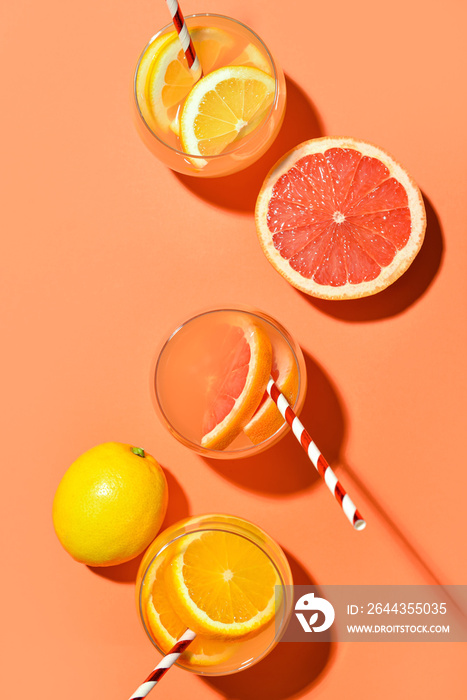 Composition with glasses of lemonade and citrus fruits on color background