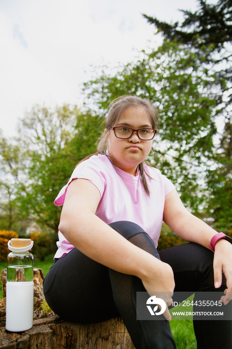 Young curvy girl with Down Syndrome relaxing after workout