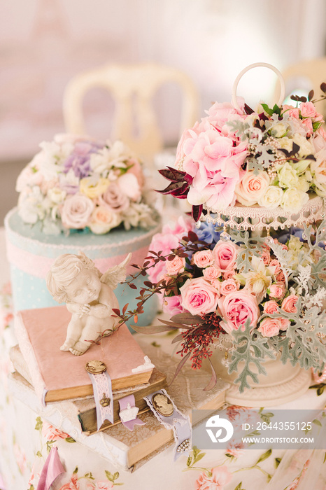 table setting at country wedding reception, wedding floral decoration, wrapped books and angel statuette