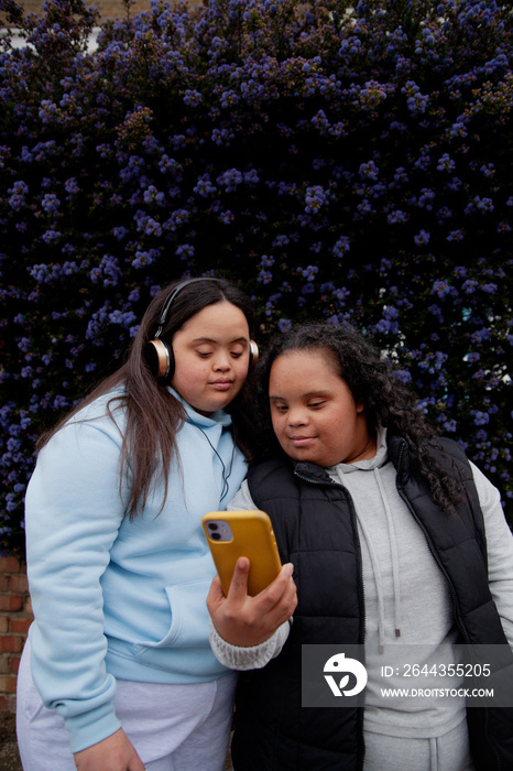 Two plus-sized women with Down Syndrome watching a video on a phone