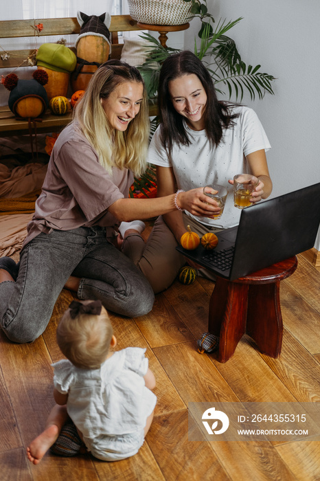 Thanksgiving online, virtual thanksgiving dinner, celebrate family and show gratitude in new normal. Online meeting with family and friends in covid pandemic time. Two young women near laptop