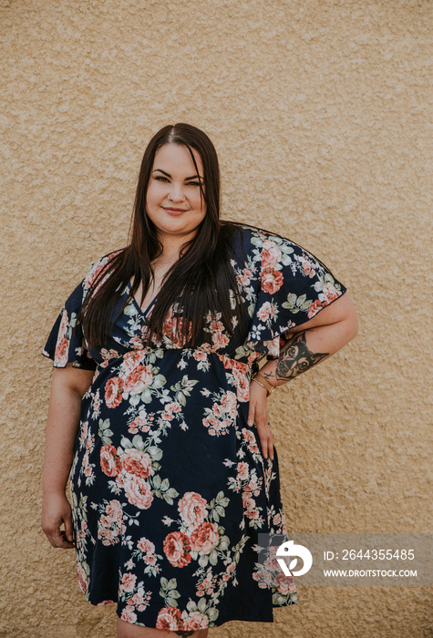 portrait of a plus size Metis woman against concrete wall