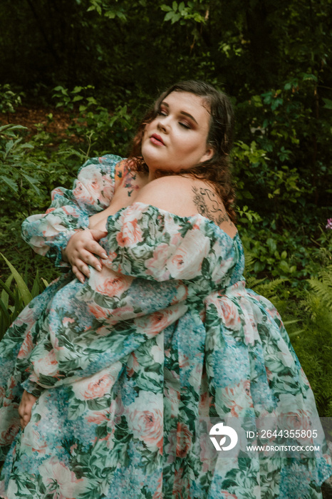 close up portrait of a plus size woman hugging self in a garden