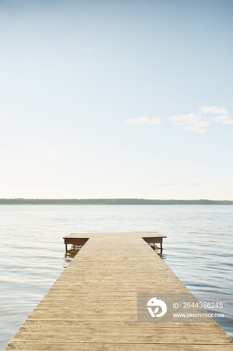 Forest river (lake) on a sunny day. Wooden pier. Clea sky, reflections in a crystal clear water. Idyllic landscape, rural scene. Nature, ecology, ecotourism, hiking, ecological resort, local tourism