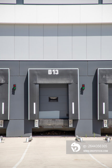 Row of loading docks with shutter doors at warehouse. Row gate.