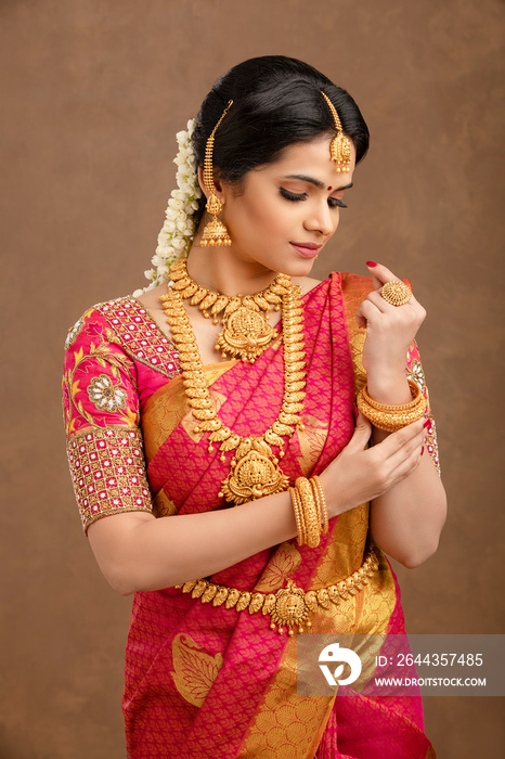 Beautiful Indian young Hindu Bride against brown background in studio shot