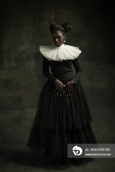 Medieval African young woman in black vintage dress with big white collar posing isolated on dark green background. Concept of comparison of eras, modernity and renaissance.