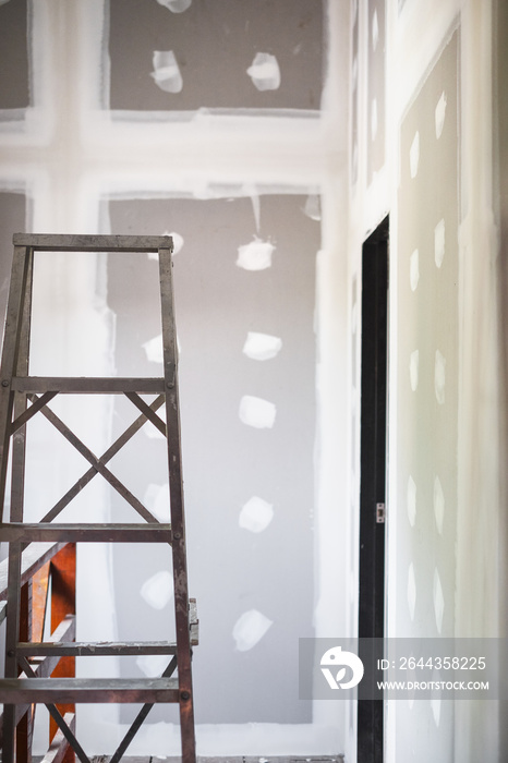 Stair in empty room interior new ceiling plaster gypsum board in construction site.