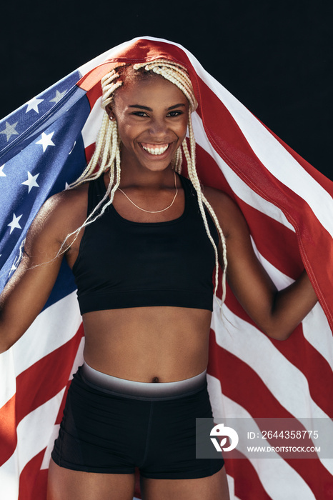 Female athlete celebrating victory holding american flag