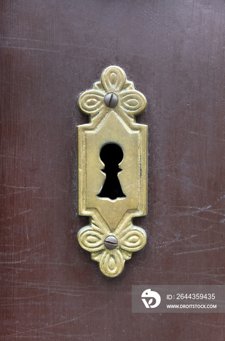 A vintage antique keyhole in old scratched wooden door