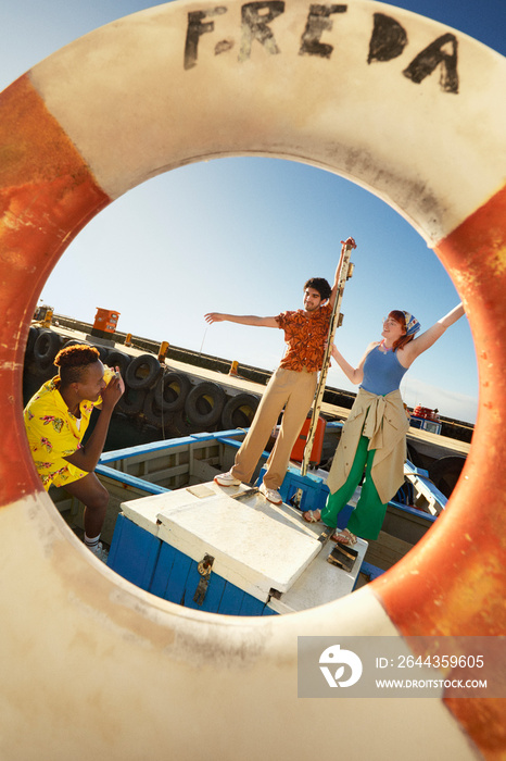 Friends having fun and posing on a boat during summer vacation in Cape Town