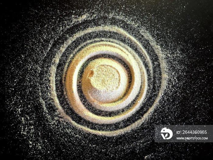 Sand spiral on the black background. The concept of rotation, golden ratio, galaxy.