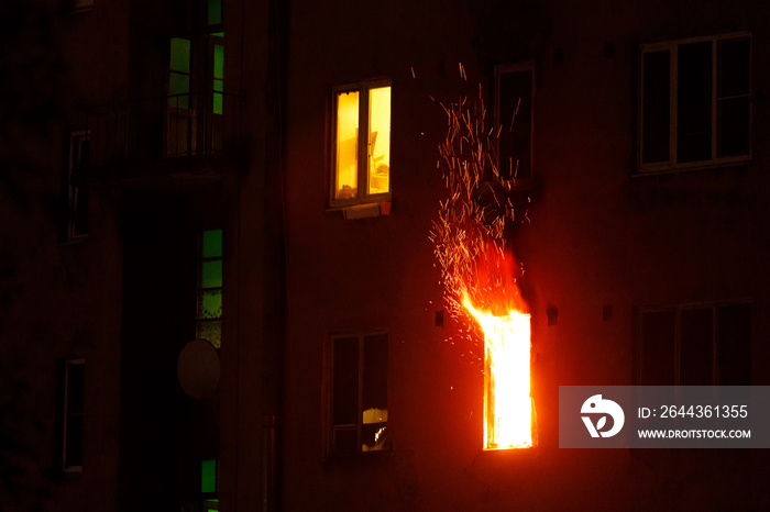 a residential apartment building is on fire at night