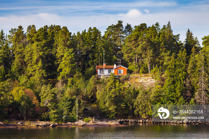 View on small cabins on an island in Stockholm archipelago, Sweden. Summer sunrise time.