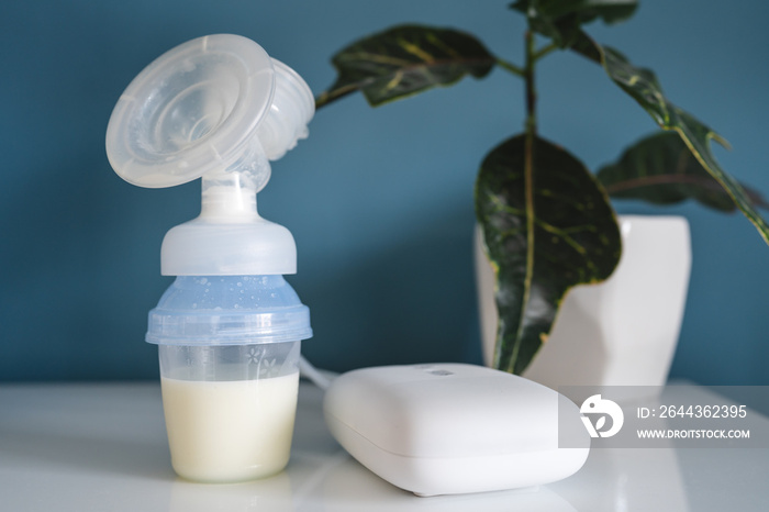 Electric Breast Pump Breastfeeding Machine and bottle with milk copy space