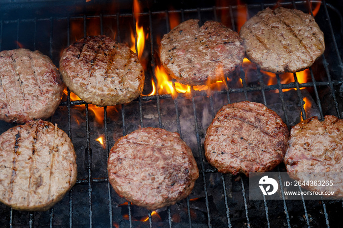 Burgers flame grilling on a BBQ