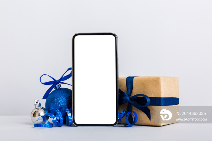 Digital phone mock up with rustic Christmas decorations for app presentation with empty space for you design. Christmas online shopping concept. Tablet with copy space on colored background