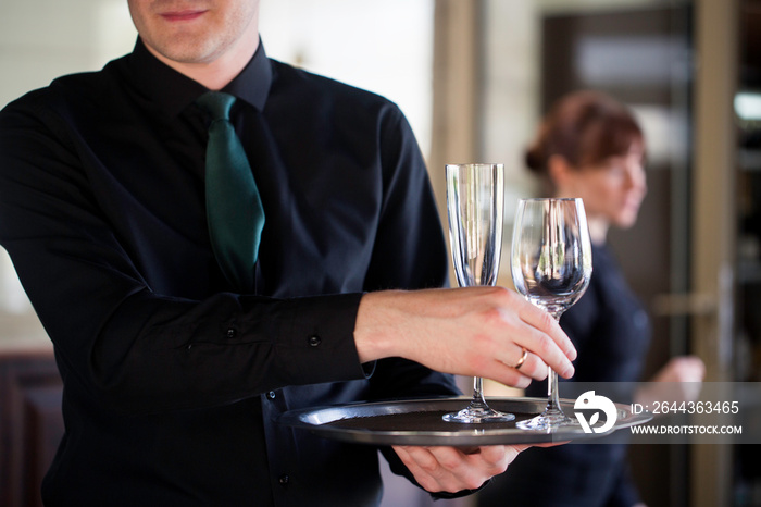 Waiter carrying glasses of wine on a tray