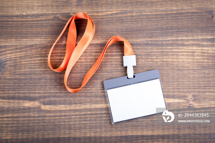 White empty staff identity mockup with orange lanyard. Name tag, ID card. Wood texture background