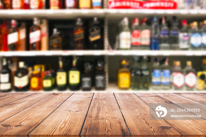 Wood table top and wine Liquor bottle on shelf blurred background