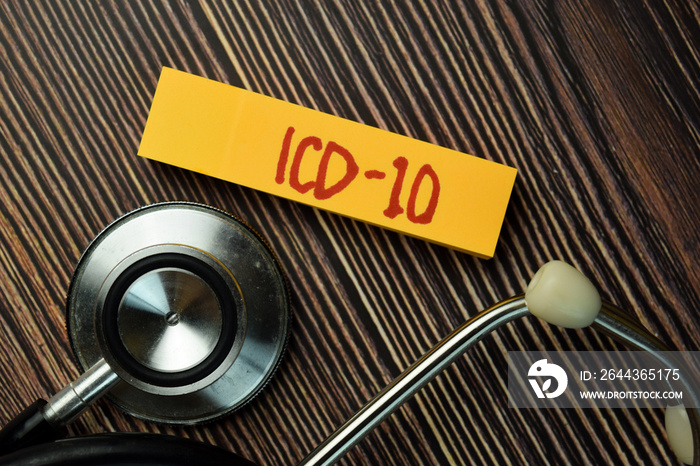 ICD - 10 write on sticky note and stethoscope isolated on Wooden Table. Medical Concept