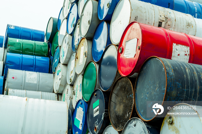 Old chemical barrels with flammable liquid warning label . Steel oil tank. Toxic waste in metal tank. Hazardous chemical barrel. Hazard waste storage in factory. Chemical barrels stack. Oil brent.