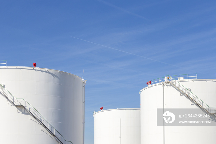 white tanks in tank farm with iron staircase