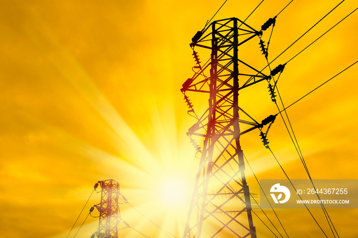 close up electricity power line tower over orange color sunset sky with shining sun