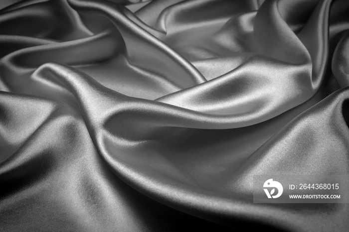 Black silk texture luxurious satin for abstract background. Dark tone of fabric