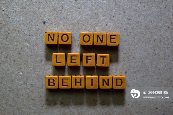 No One Left Behind on wooden cubes. On table background