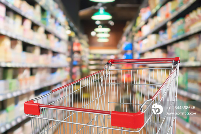 supermarket aisle blur abstract background with empty red shopping cart