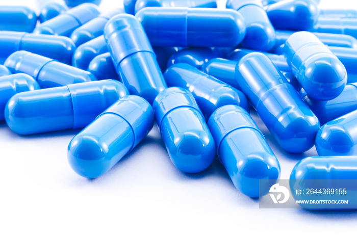 Blue capsules pill on white background. Antibiotics drug resistance.