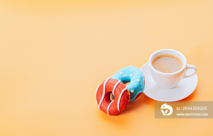 donuts one with blue icing and white stars and with red icing and white stripes and a cup of coffee on a yellow background