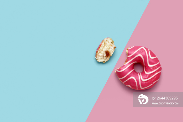 Bitten donut on pink and blue background