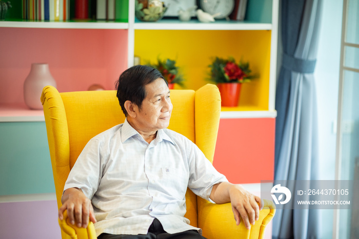 Asian grandfather relax time on chair in living room at home