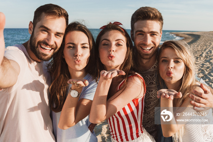 Group of happy friends spending time together at the beach