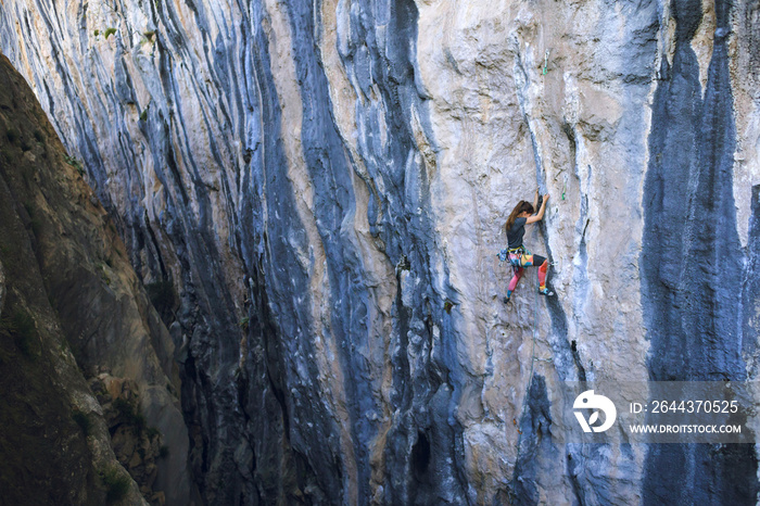 A strong girl climbs a rock, Rock climbing in Turkey.