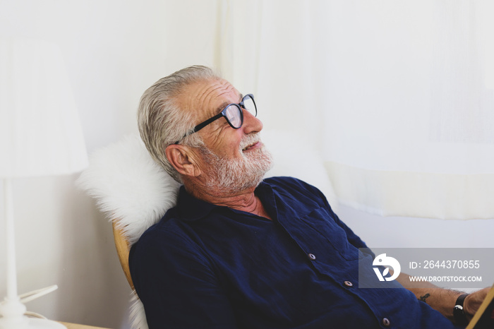 Senior man sitting alone for relaxation and smile portrait in home.