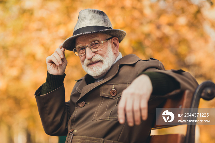 Closeup photo of funny charming old pensioner grey haired grandpa central park walk enjoy sunny day sit bench greet people nod head cap wear stylish autumn jacket specs colorful street outside