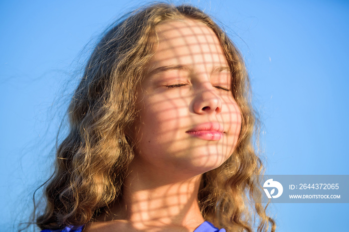 Take care. Summer care. Sunscreen concept. Child pleased with warm sunlight looks relaxed blue sky background. Take care skin put sunscreen cosmetics. Girl kid relaxing outdoors. Uv filter sunscreen