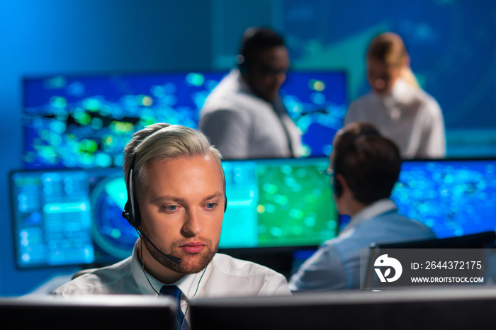 Workplace of the air traffic controllers in the control tower. Diverse team of aircraft control officers works using radar, computer navigation and digital maps. Aviation concept.