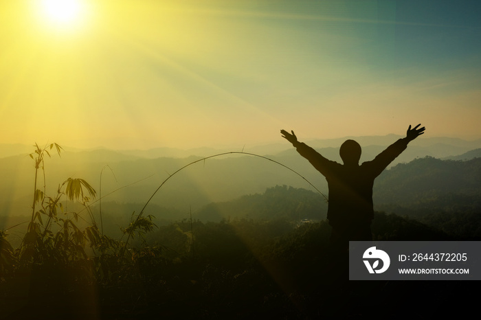 The man raised his arm up the mountain. He thanked God.