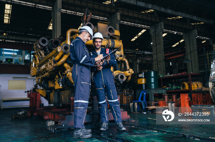 the technician repairing and inspecting the big diesel engine in the train garage