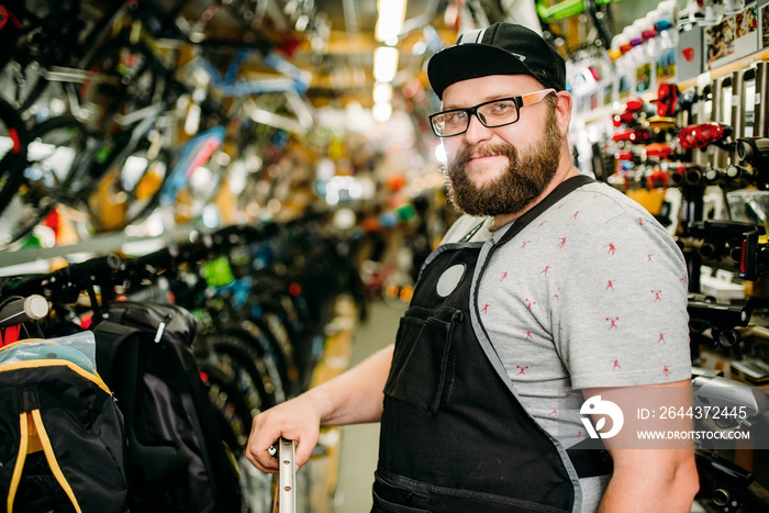 Bicycle mechanic with wheel in bike shop