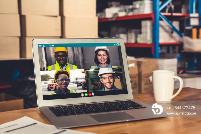 Warehouse staff talking on video call at computer screen in storage warehouse . Online software technology connects people working in logistic factory by virtual conference call on internet network .