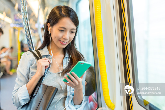 Woman listen to song on phone and taking the train in Hong Kong