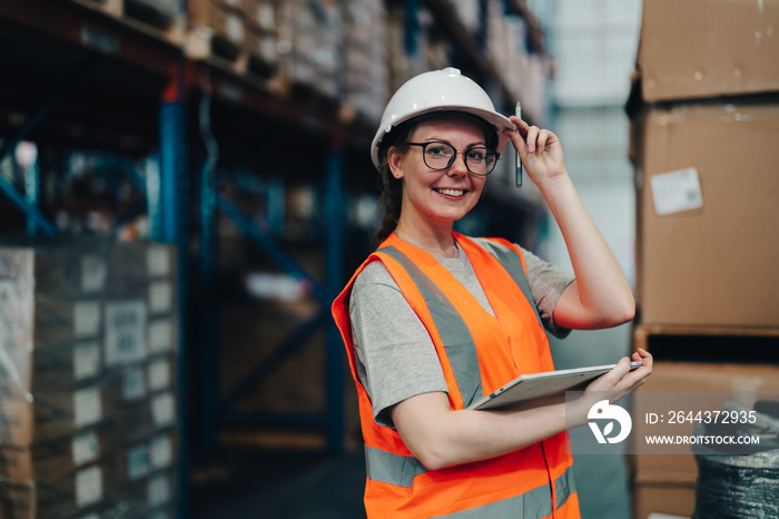 Portrait of a warehouse worker standing in a distribution center. Caucasian female looking at camera. concept of occupation and career.